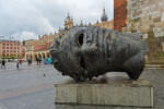Skulptur ,Eros Bendato' von Igor Mitora, die einen liegenden hohlen Bronzekopf zeigt
